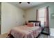 This comfortable bedroom has pink bedding, blackout curtains, and mirrored nightstands to create a soothing space at 2933 Maiden Grass Isle, Wesley Chapel, FL 33543