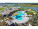 Stunning aerial view of the resort-style community pool area, featuring lounge seating, cabanas, and lush landscaping at 2933 Maiden Grass Isle, Wesley Chapel, FL 33543