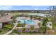 Beautiful aerial view of the community pool, showcasing cabanas, lounge chairs, and lush landscaping by a pond at 2933 Maiden Grass Isle, Wesley Chapel, FL 33543