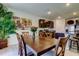 Dining area featuring a wooden table, chairs, and a painting, connecting seamlessly to the kitchen at 2933 Maiden Grass Isle, Wesley Chapel, FL 33543