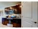 Kitchen featuring granite countertops, stainless steel appliances, and dark cabinets at 2933 Maiden Grass Isle, Wesley Chapel, FL 33543