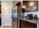 Kitchen with stainless steel refrigerator, dark cabinets and granite countertops plus coffee bar at 2933 Maiden Grass Isle, Wesley Chapel, FL 33543