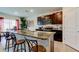 Kitchen island with granite countertops, seating, and views of dining area and kitchen at 2933 Maiden Grass Isle, Wesley Chapel, FL 33543