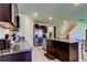 Modern kitchen featuring stainless steel appliances, granite countertops, an island, and dark wood cabinets at 2933 Maiden Grass Isle, Wesley Chapel, FL 33543
