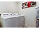 This laundry room is equipped with a Whirlpool washing machine and dryer, along with an ironing board at 2933 Maiden Grass Isle, Wesley Chapel, FL 33543