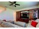 Inviting living room featuring a ceiling fan and a custom entertainment center with a large television screen at 2933 Maiden Grass Isle, Wesley Chapel, FL 33543
