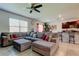 Open living area with a large sectional couch, adjacent to a kitchen with counter seating at 2933 Maiden Grass Isle, Wesley Chapel, FL 33543
