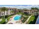 Aerial view of a community with a pool, palm trees, and lush landscaping. Perfect for relaxation and enjoyment at 3021 Countryside Blvd # 45A, Clearwater, FL 33761