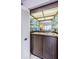 Retro bar with glass shelving, a sink, and wood cabinets at 3021 Countryside Blvd # 45A, Clearwater, FL 33761