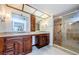 Bright bathroom with granite counters, double sinks, wood cabinets, and a tiled walk-in shower with grab bars at 3021 Countryside Blvd # 45A, Clearwater, FL 33761