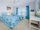 Bright bedroom with two twin beds, white furniture, blue curtains, and a large window for natural light at 3021 Countryside Blvd # 45A, Clearwater, FL 33761