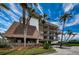 Multi-story building with well-manicured landscaping and palm trees under a sunny sky at 3021 Countryside Blvd # 45A, Clearwater, FL 33761