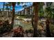 Landscaped condominium exterior featuring a decorative water feature, mature trees, and lush tropical plants at 3021 Countryside Blvd # 45A, Clearwater, FL 33761