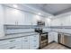 Renovated kitchen featuring stainless steel appliances, white cabinetry, and modern countertops at 3021 Countryside Blvd # 45A, Clearwater, FL 33761