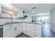 Bright kitchen with white cabinets, subway tile, stainless steel appliances, and a view to the dining area at 3021 Countryside Blvd # 45A, Clearwater, FL 33761