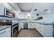 Modern kitchen with stainless steel appliances, white cabinetry, and subway tile backsplash at 3021 Countryside Blvd # 45A, Clearwater, FL 33761