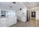 Bright kitchen with white cabinets, stainless steel appliances, and gray wood-look flooring at 3021 Countryside Blvd # 45A, Clearwater, FL 33761