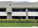 Close-up exterior of the building featuring balconies and a view of the green space at 36750 Us 19 N # 4-205, Palm Harbor, FL 34684
