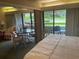 Bedroom featuring a bed and a dining area with a table and chairs near a balcony with green views at 36750 Us 19 N # 4-205, Palm Harbor, FL 34684