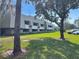 Exterior of building showing brick facade, and large manicured lawn at 36750 Us 19 N # 4-205, Palm Harbor, FL 34684