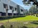 Exterior view showcasing the property's architecture, manicured lawn, and lush landscaping at 36750 Us 19 N # 4-205, Palm Harbor, FL 34684