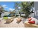 A backyard paradise with stylish wooden furniture, a slide, and mature tropical landscaping at 4106 W Cleveland St, Tampa, FL 33609