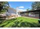 A well-manicured backyard with a grassy area and a screened-in pool area with outdoor furniture at 4106 W Cleveland St, Tampa, FL 33609
