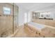 Bright bathroom featuring a double vanity, glass shower, and soaking tub at 4106 W Cleveland St, Tampa, FL 33609
