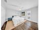 Bright bedroom with hardwood floors, white walls, and a bed with plush white bedding at 4106 W Cleveland St, Tampa, FL 33609