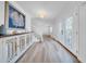 Bright foyer featuring stylish wood-look flooring, elegant staircase, and decorative console table with nautical accents at 4106 W Cleveland St, Tampa, FL 33609