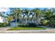 Elegant two-story home featuring mature palm trees, lush landscaping, and a spacious front yard at 4106 W Cleveland St, Tampa, FL 33609