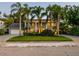 Elegant two-story home featuring mature palm trees, lush landscaping, and a spacious front yard at 4106 W Cleveland St, Tampa, FL 33609