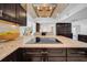 Modern kitchen featuring granite counters, an island cooktop, stainless steel appliances, and dark wood cabinetry at 4106 W Cleveland St, Tampa, FL 33609