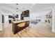 Bright open-concept living area featuring hardwood floors, a bar with seating, and access to the Gathering room at 4106 W Cleveland St, Tampa, FL 33609