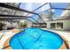 Sparkling in-ground pool and spa surrounded by a screened-in patio with lush landscaping at 4106 W Cleveland St, Tampa, FL 33609