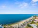 Aerial view of a coastal community featuring houses near a tranquil beach and the serene ocean at 4210 Headsail Dr, New Port Richey, FL 34652