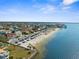 This aerial view showcases a beautiful beach community with homes, palm trees, and stunning ocean views at 4210 Headsail Dr, New Port Richey, FL 34652