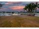 Fenced in backyard view of a waterfront property featuring a boat dock at sunset at 422 Islebay Dr, Apollo Beach, FL 33572