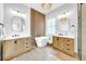 Luxurious bathroom featuring double vanities, a freestanding tub, and modern wood and tile accents at 422 Islebay Dr, Apollo Beach, FL 33572