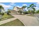 A charming two-story home with an attached garage and palm trees along the walkway and driveway at 422 Islebay Dr, Apollo Beach, FL 33572