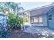 A shaded outdoor patio with access to the backyard, featuring brick pavers, lush tropical foliage and ample light at 510 55Th Ne Ave, St Petersburg, FL 33703