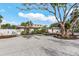Single-story home with a two-car garage, brick driveway, complemented by charming landscaping and mature trees at 5430 Avenida Del Mare, Sarasota, FL 34242