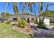 Charming single-story home featuring a well-maintained front yard with mature landscaping at 5619 New York Ave, Sarasota, FL 34231