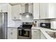Stylish kitchen with stainless steel oven and range hood, plus crisp white cabinets and countertops at 5619 New York Ave, Sarasota, FL 34231