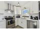 Well-lit kitchen with stainless steel appliances, white subway tile, and light gray floors at 5619 New York Ave, Sarasota, FL 34231