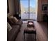 View of balcony from inside the living room, which has a comfortable sofa and ottoman at 628 Cleveland St # 612, Clearwater, FL 33755