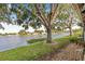 Tranquil backyard view with mature trees and waterfront access to a serene canal at 6497 Cape Hatteras Ne Way # 3, St Petersburg, FL 33702