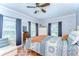 Bright bedroom features a ceiling fan, windows with blue curtains, and stylish décor at 713 W Kentucky Ave, Tampa, FL 33603