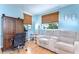 Home office features a comfortable sofa, wooden blinds, and large wooden desk and cabinet at 713 W Kentucky Ave, Tampa, FL 33603