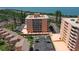 Aerial view showcasing a waterfront condo building with a tennis court, balconies, and a parking lot at 7432 Sunshine Skyway S Ln # 406, St Petersburg, FL 33711